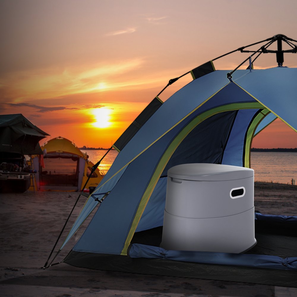 Inodoro portátil VEVOR dentro de una tienda de campaña en una playa al atardecer. Equipo de acampada visible en el fondo.