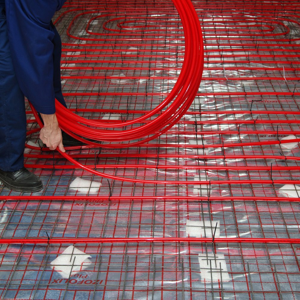 Instalación de tubería pex VEVOR en un sistema de calefacción por suelo radiante con tubería roja y base.