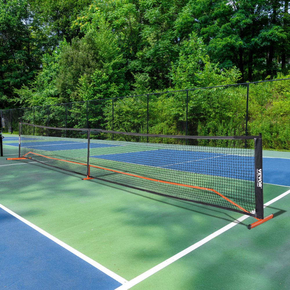 Red de pickleball VEVOR ubicada en una cancha al aire libre con frondosos árboles verdes de fondo.