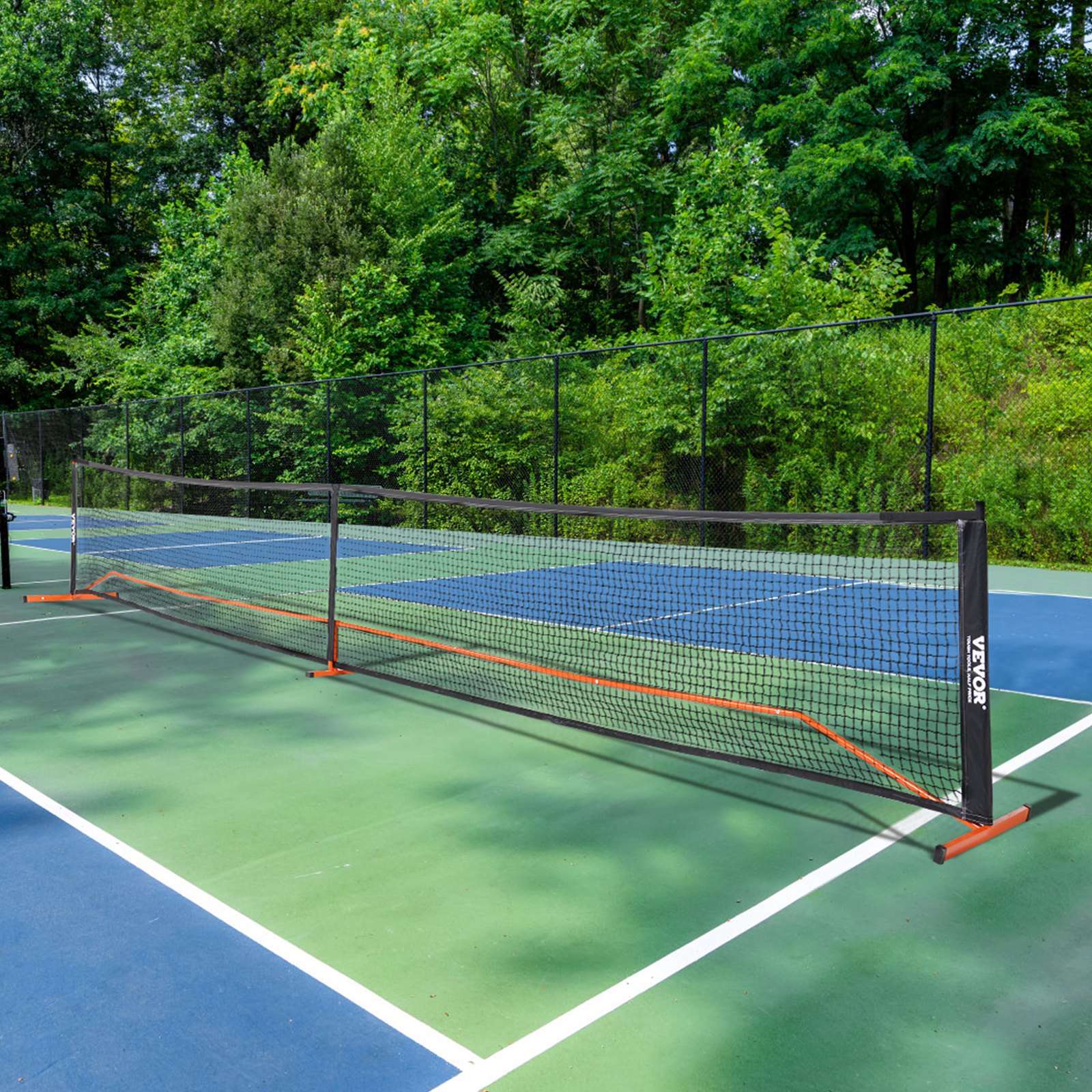 Red de pickleball VEVOR ubicada en una cancha al aire libre con frondosos árboles verdes de fondo.