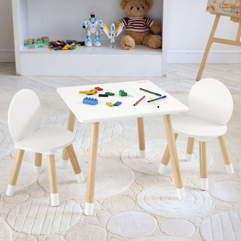 Juego de mesa para niños VEVOR con dos sillas blancas, bloques de construcción de colores, crayones y juguetes en una sala de juegos.