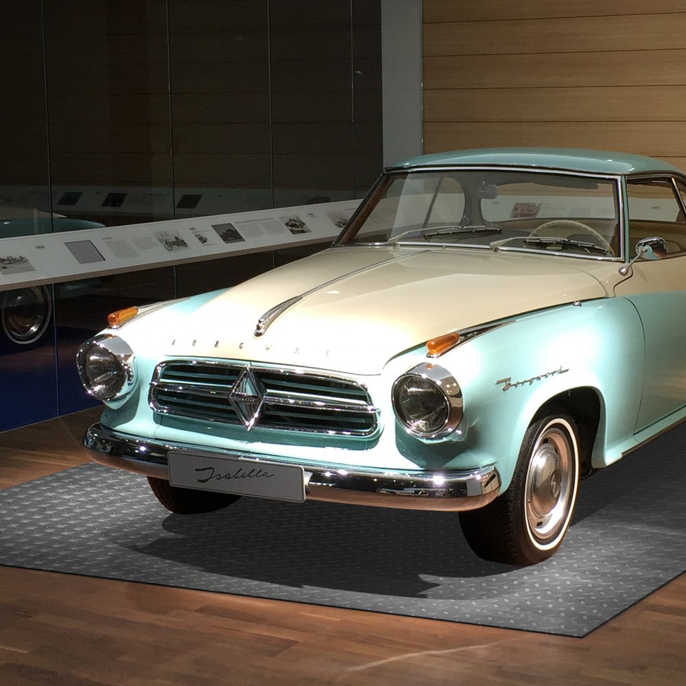 Coche clásico exhibido en la alfombra del piso del garaje VEVOR en la sala de exposición.