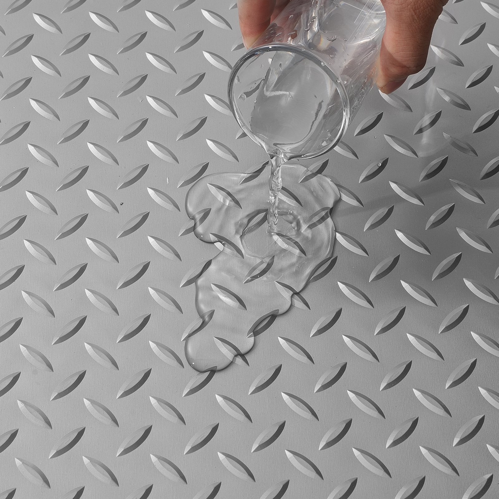 verter agua sobre la alfombra de garaje antideslizante VEVOR con textura de placa de diamante.