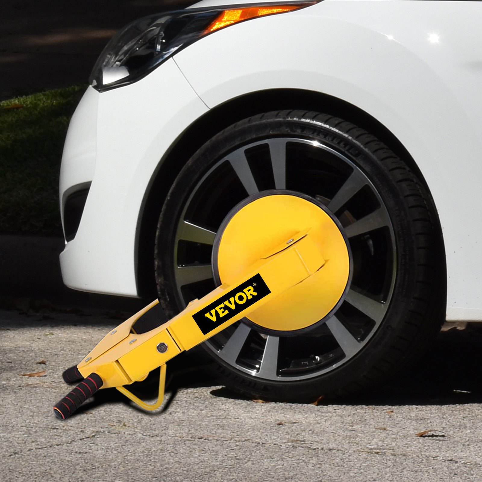 Abrazadera de bloqueo de rueda VEVOR amarilla que fija un neumático de automóvil blanco.