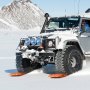 SUV usando placas de tracción VEVOR en terreno nevado con fondo montañoso.