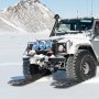 SUV todoterreno sobre nieve usando placas de tracción VEVOR con una montaña cubierta de nieve al fondo.