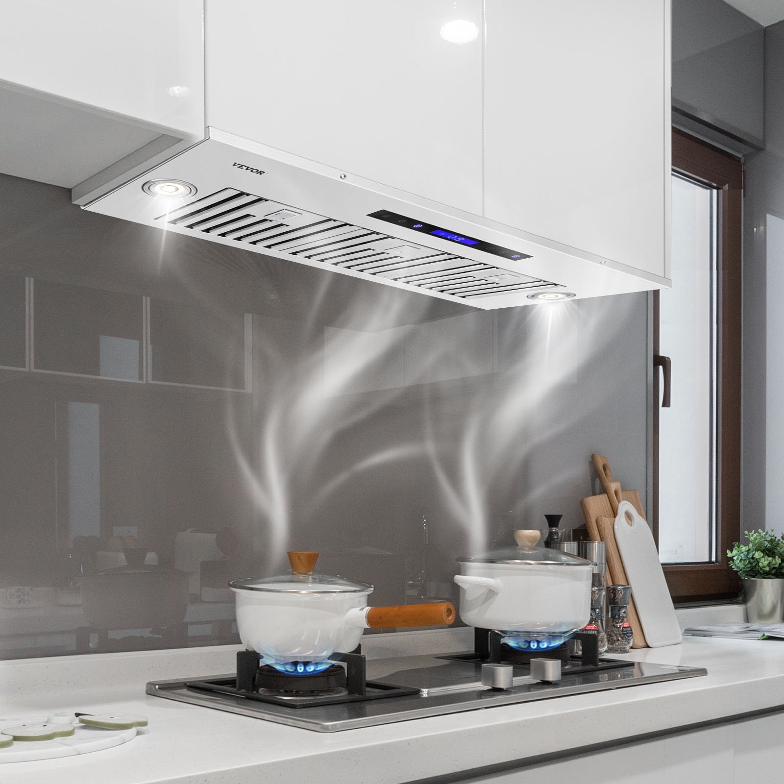 Cocina moderna con campana extractora insertable VEVOR encima de la estufa, que ventila el vapor de las ollas sobre los quemadores.
