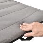 mano tocando la suave superficie de un cojín de masaje de cuerpo completo VEVOR en gris.