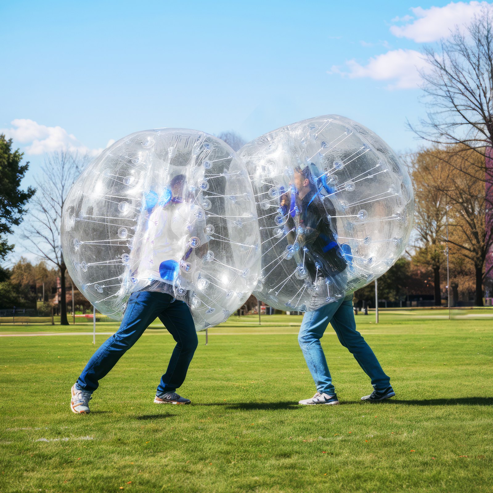 Dos personas jugando en el césped con pelotas inflables VEVOR bajo un cielo azul claro.