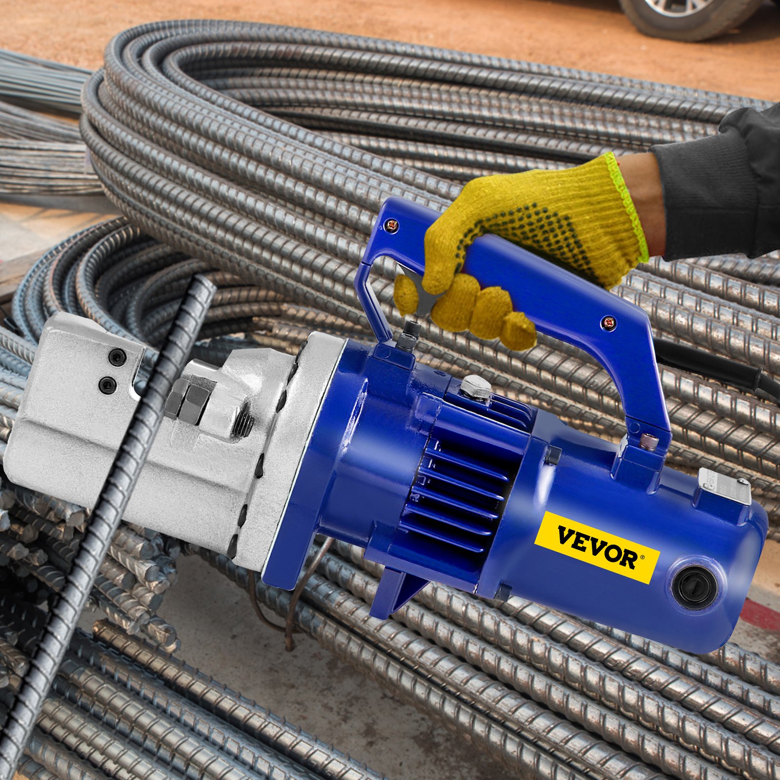 Trabajador que utiliza un cortador de varillas de refuerzo VEVOR azul sobre una pila de varillas de refuerzo.