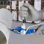 Trabajador que utiliza el kit de flejado y bandas VEVOR en un almacén con paquetes apilados.