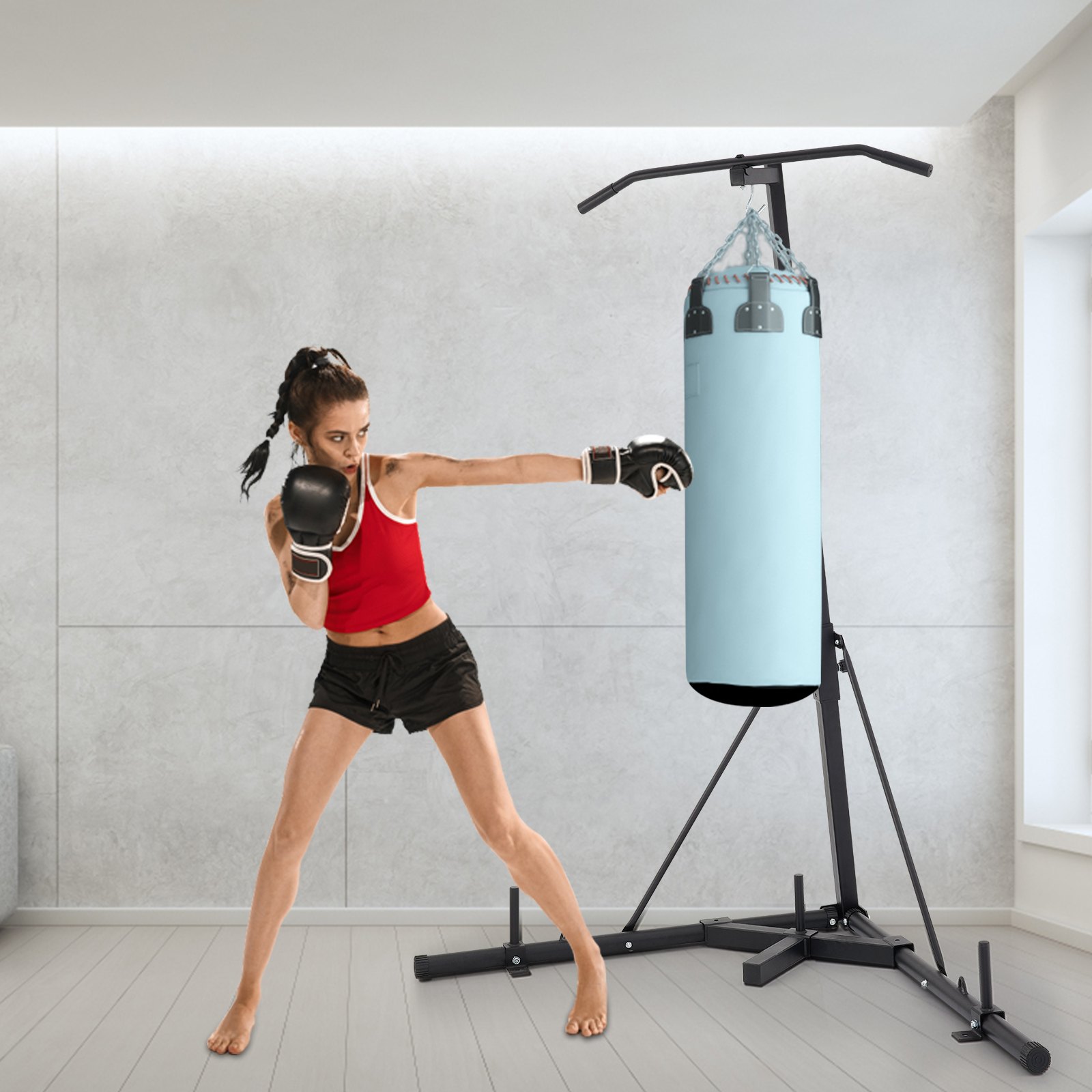 Mujer boxeando con un soporte para bolsa pesada VEVOR en un moderno gimnasio interior.