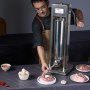 Hombre operando una embutidora de salchichas VEVOR, llenando la tripa de salchicha con carne, rodeado de ingredientes.