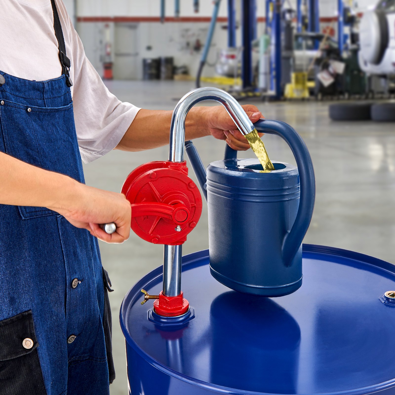 Persona que utiliza una bomba de tambor VEVOR para verter líquido en un recipiente azul en un entorno industrial.