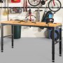Banco de trabajo ajustable VEVOR en un garaje con herramientas en la superficie, bicicletas y equipo deportivo en el fondo.