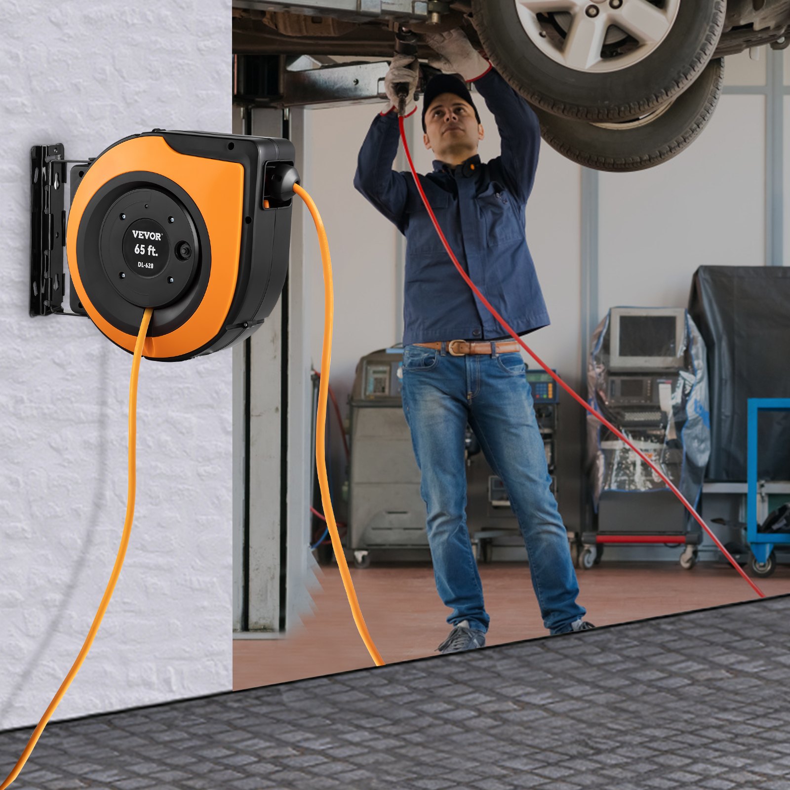 Mecánico que utiliza un carrete de cable de extensión retráctil VEVOR en un garaje con el coche elevado.