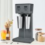 Máquina para hacer batidos VEVOR con vasos mezcladores dobles sobre una encimera de cocina adornada con ingredientes y decoración.