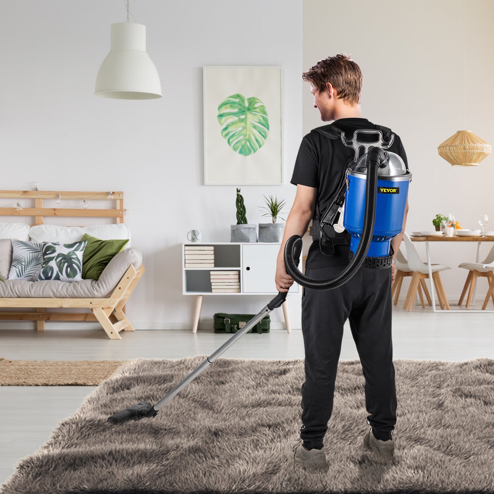 Persona que utiliza una aspiradora de mochila VEVOR sobre una alfombra de felpa en una sala de estar moderna.