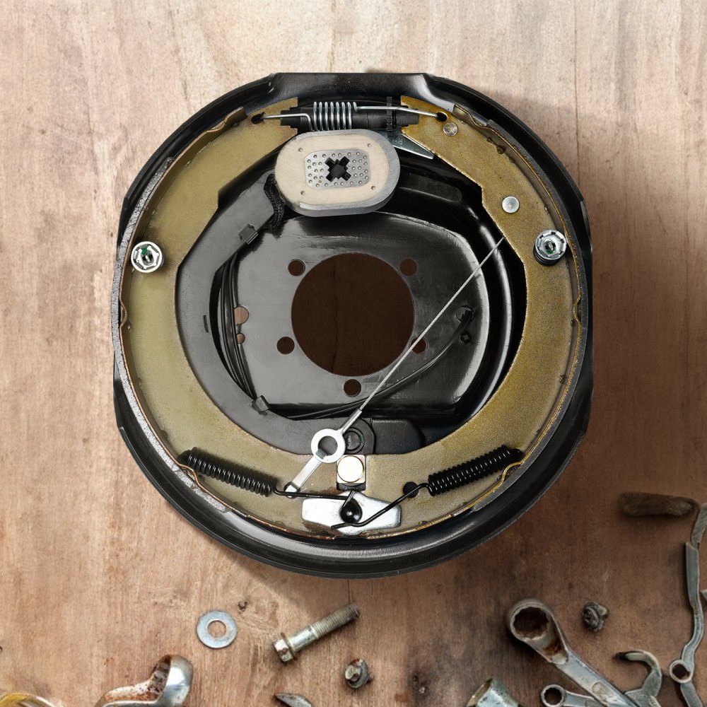 Conjunto de freno de remolque eléctrico VEVOR sobre fondo de madera con componentes de hardware dispersos.