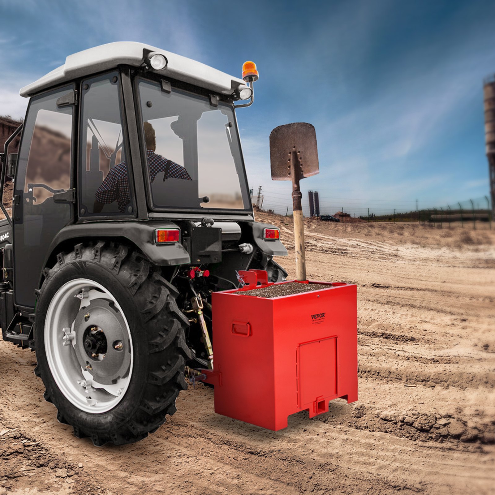 Tractor en un sitio de construcción con una caja de lastre VEVOR roja adjunta y una pala en el fondo.