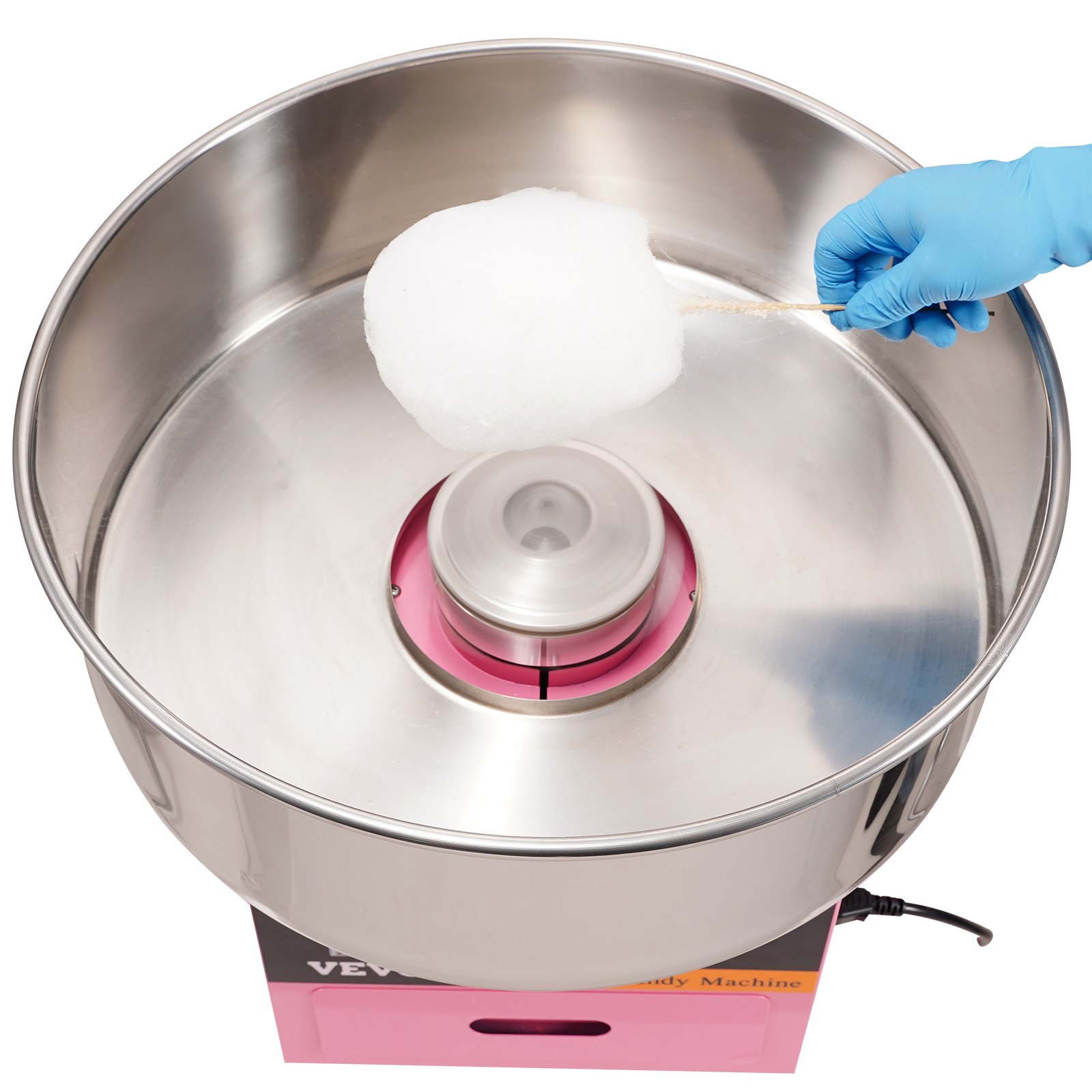 Máquina de algodón de azúcar eléctrica VEVOR con recipiente de acero inoxidable y mano que sostiene algodón de azúcar fresco.