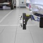 Enganche de remolque ajustable VEVOR unido a un vehículo en un estacionamiento.