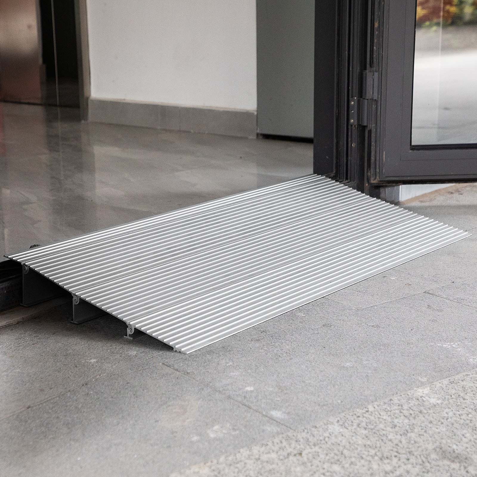 Rampa de entrada VEVOR en la entrada de la puerta, que muestra una superficie de aluminio texturizado.