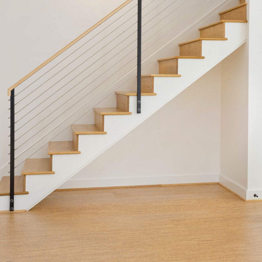 Escalera moderna de madera con barandilla negra y kit de barandilla de cable VEVOR, sobre suelo de madera clara.