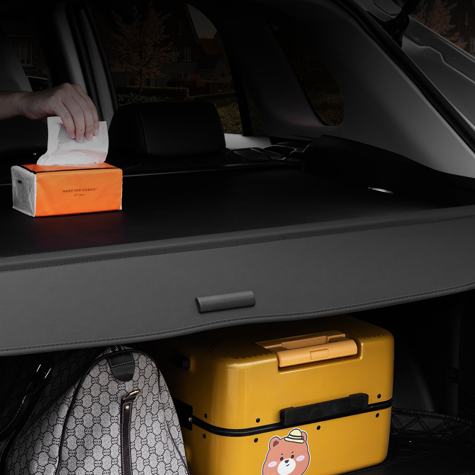 Área de carga trasera de un Honda CRV con cubierta de carga retráctil VEVOR, caja de pañuelos, equipaje y una bolsa.