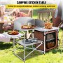 Mesa de cocina para acampar VEVOR instalada al aire libre con comida y bebidas, gente cenando de fondo.