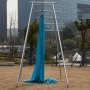 Instalación de inversión de eslinga de yoga VEVOR azul en un parque con fondo de edificios modernos.