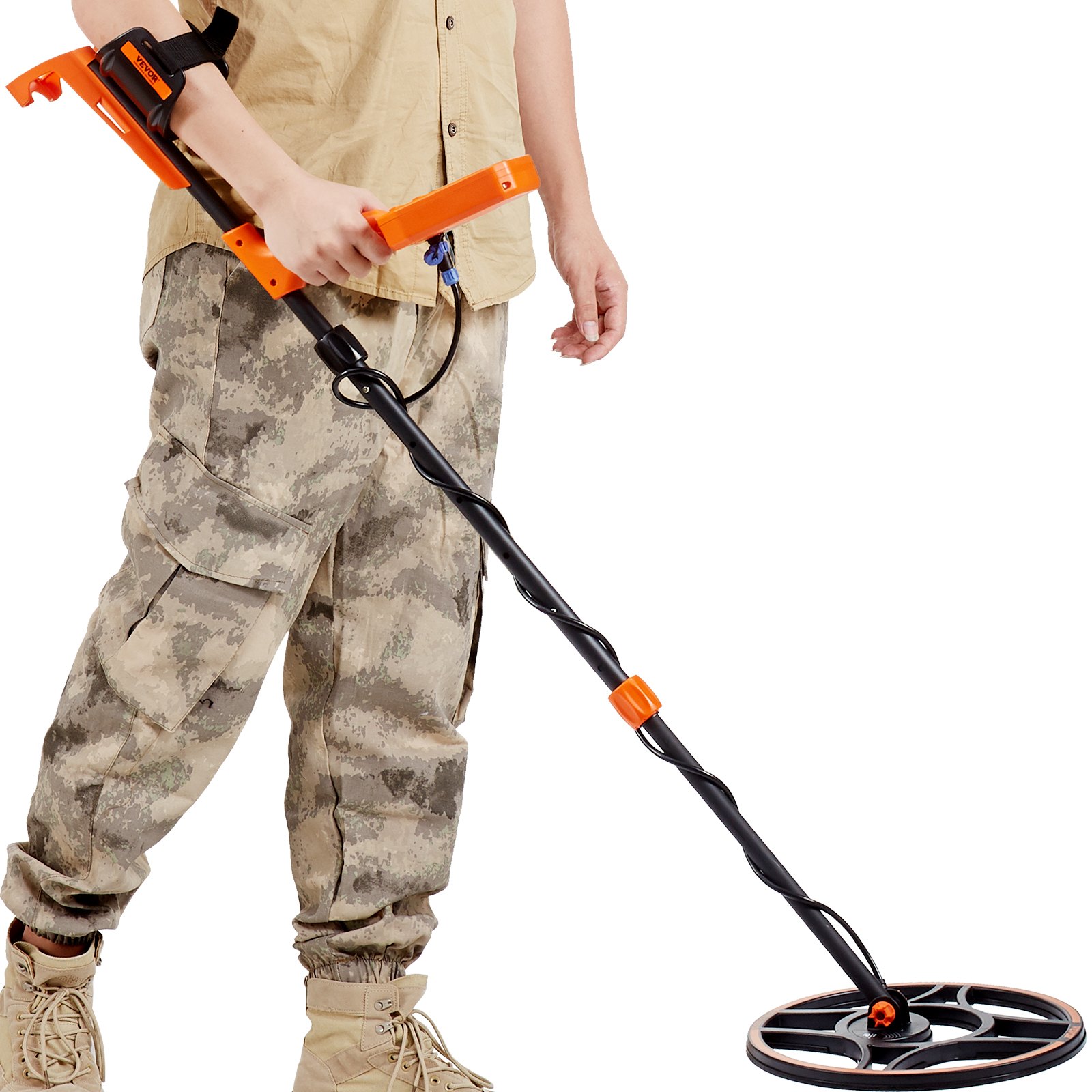 Persona que utiliza un detector de metales resistente al agua VEVOR, vistiendo pantalones de camuflaje y botas beige.
