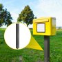 Buzón amarillo en VEVOR, buzón colocado en un parque con árboles al fondo.