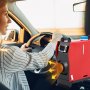 Conductor que utiliza un calentador de aire diésel VEVOR mientras conduce un automóvil en un día soleado.