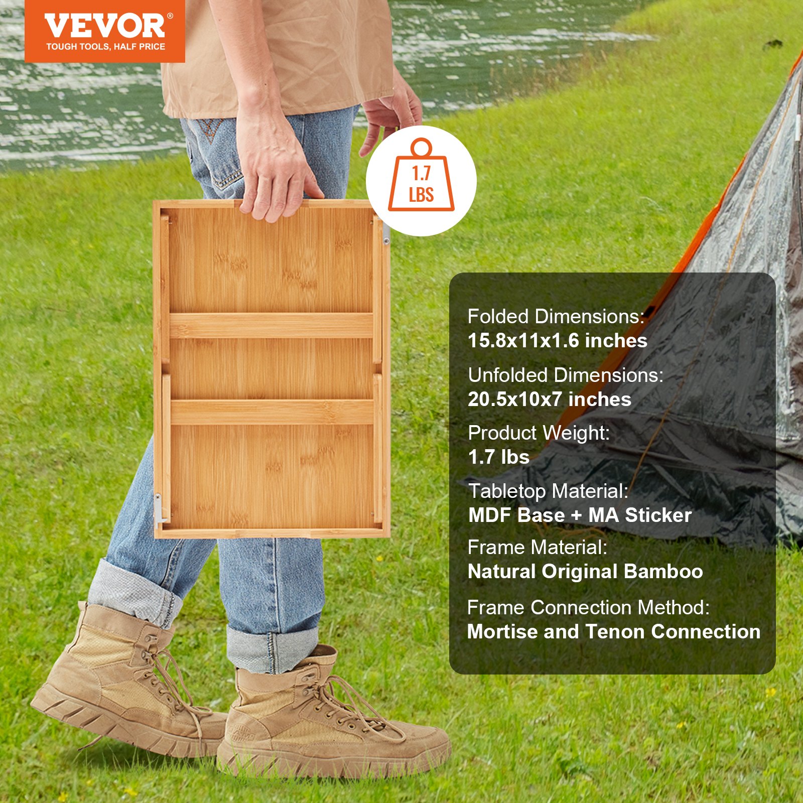 persona sosteniendo una mesa plegable de bambú VEVOR frente a un lago y una tienda de campaña.