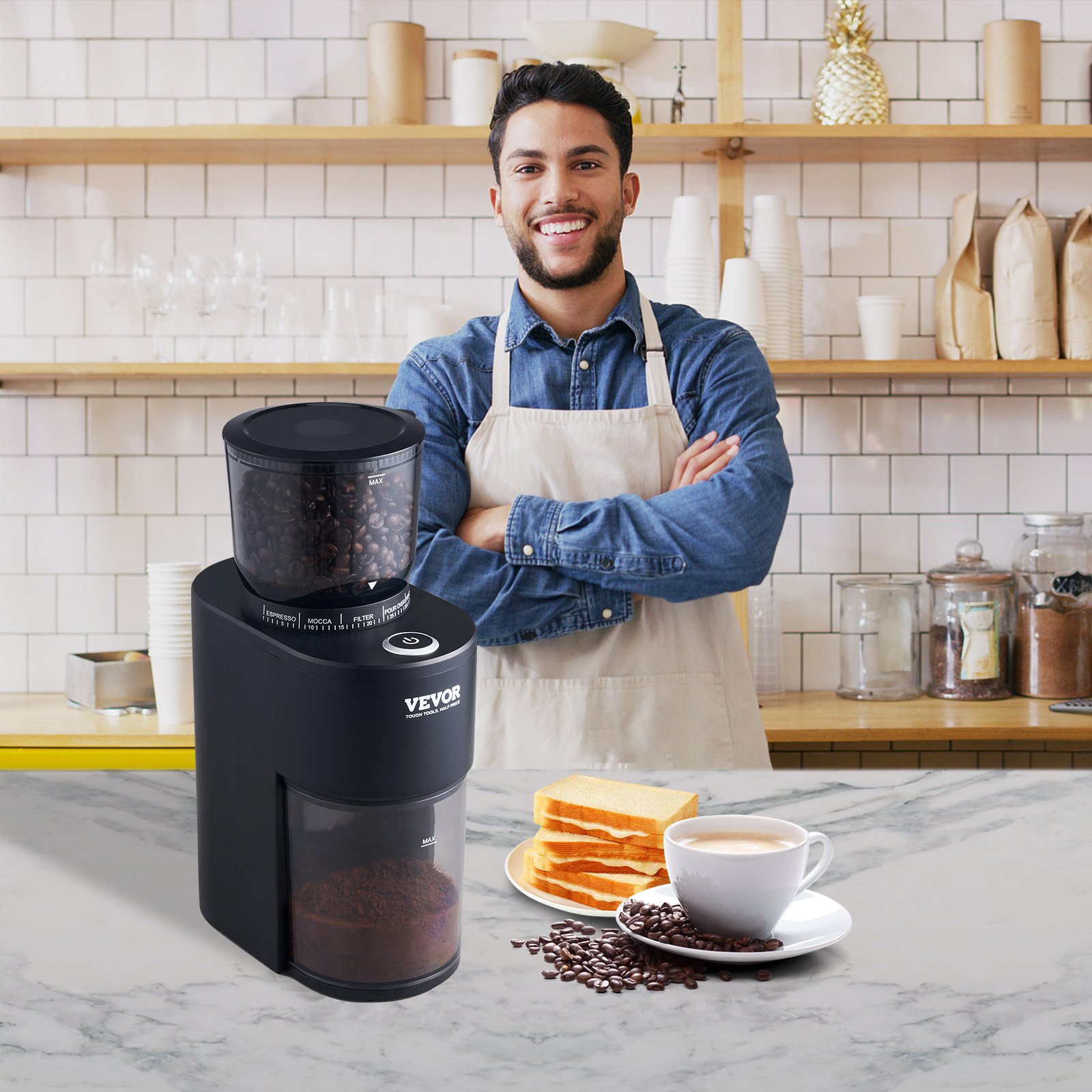 Barista de pie detrás de un molinillo de café VEVOR con granos de café, tostadas y una taza de café en el mostrador.