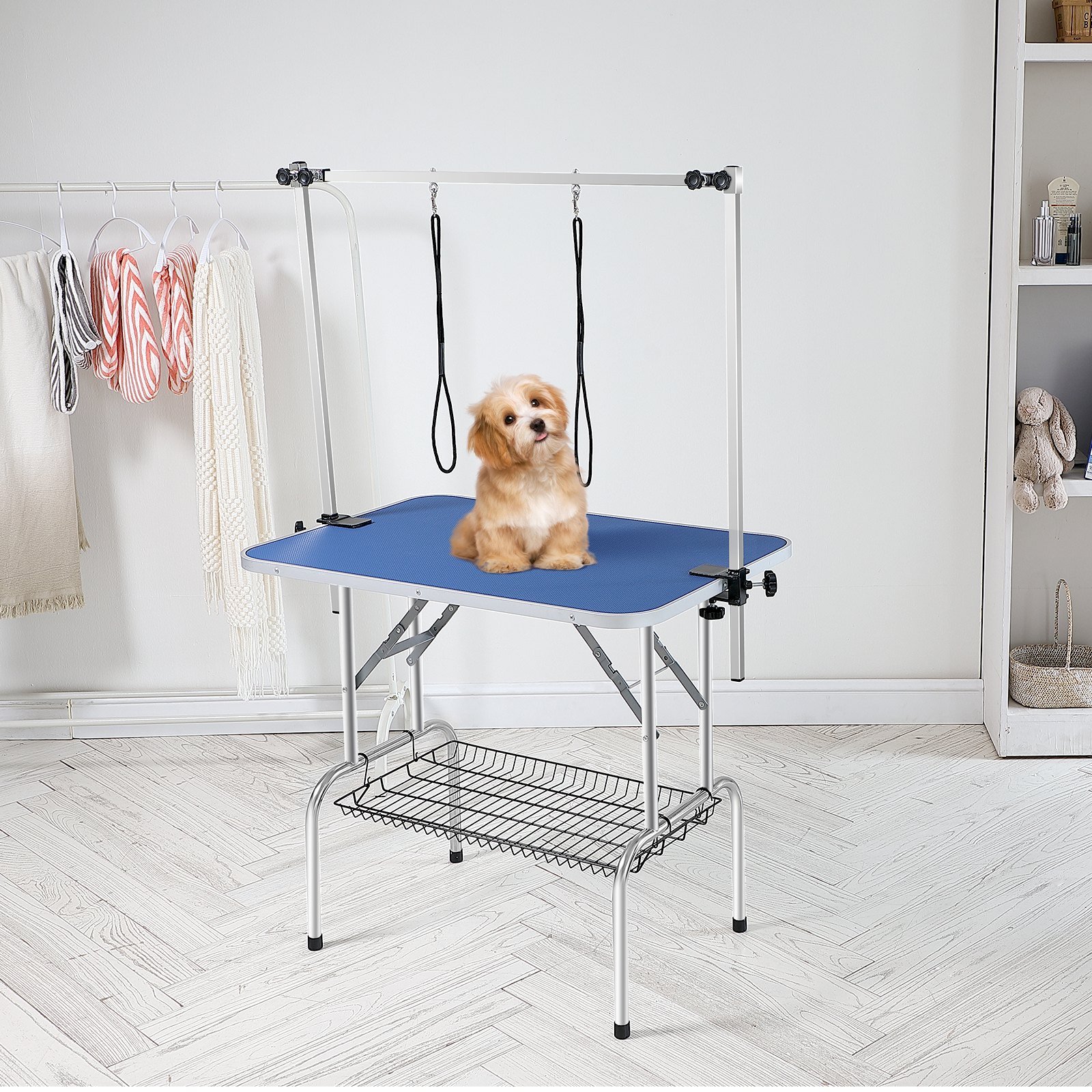 Mesa de aseo para mascotas VEVOR con superficie azul, brazo ajustable y estante de almacenamiento en una habitación moderna.