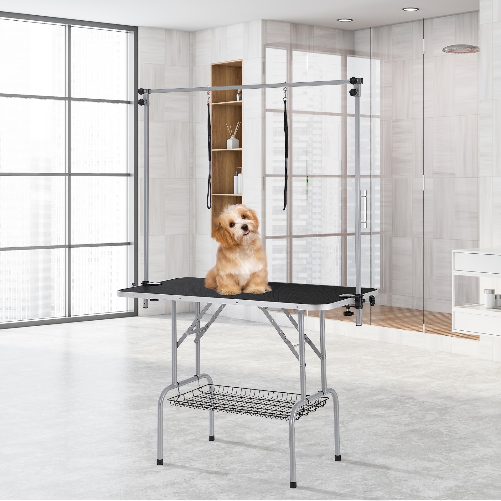 Perro en una mesa de peluquería para mascotas VEVOR en una habitación moderna y luminosa con grandes ventanales y paredes de azulejos.