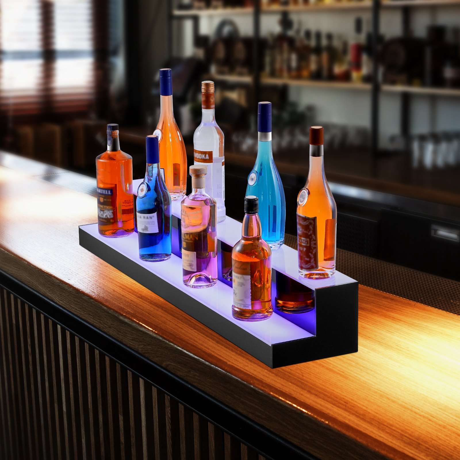 Estante para licores iluminado con LED VEVOR con botellas que brillan en colores vibrantes junto a un bar al aire libre.