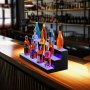 Estante de bar LED VEVOR que muestra varias botellas de licor junto a una barra junto a la piscina con una vibrante vida nocturna de fondo.