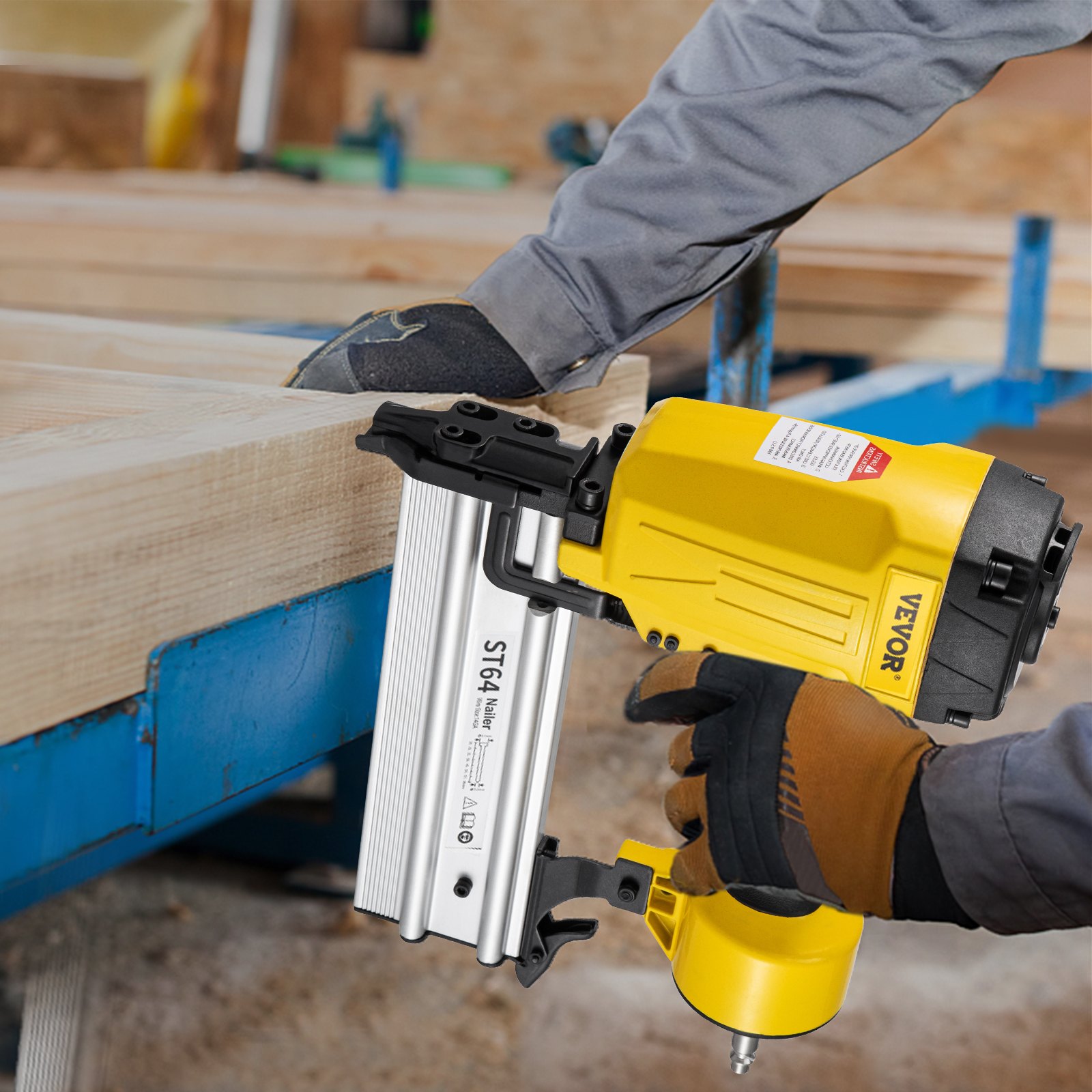 Trabajador que utiliza una clavadora de hormigón neumática VEVOR para asegurar vigas de madera en un taller.