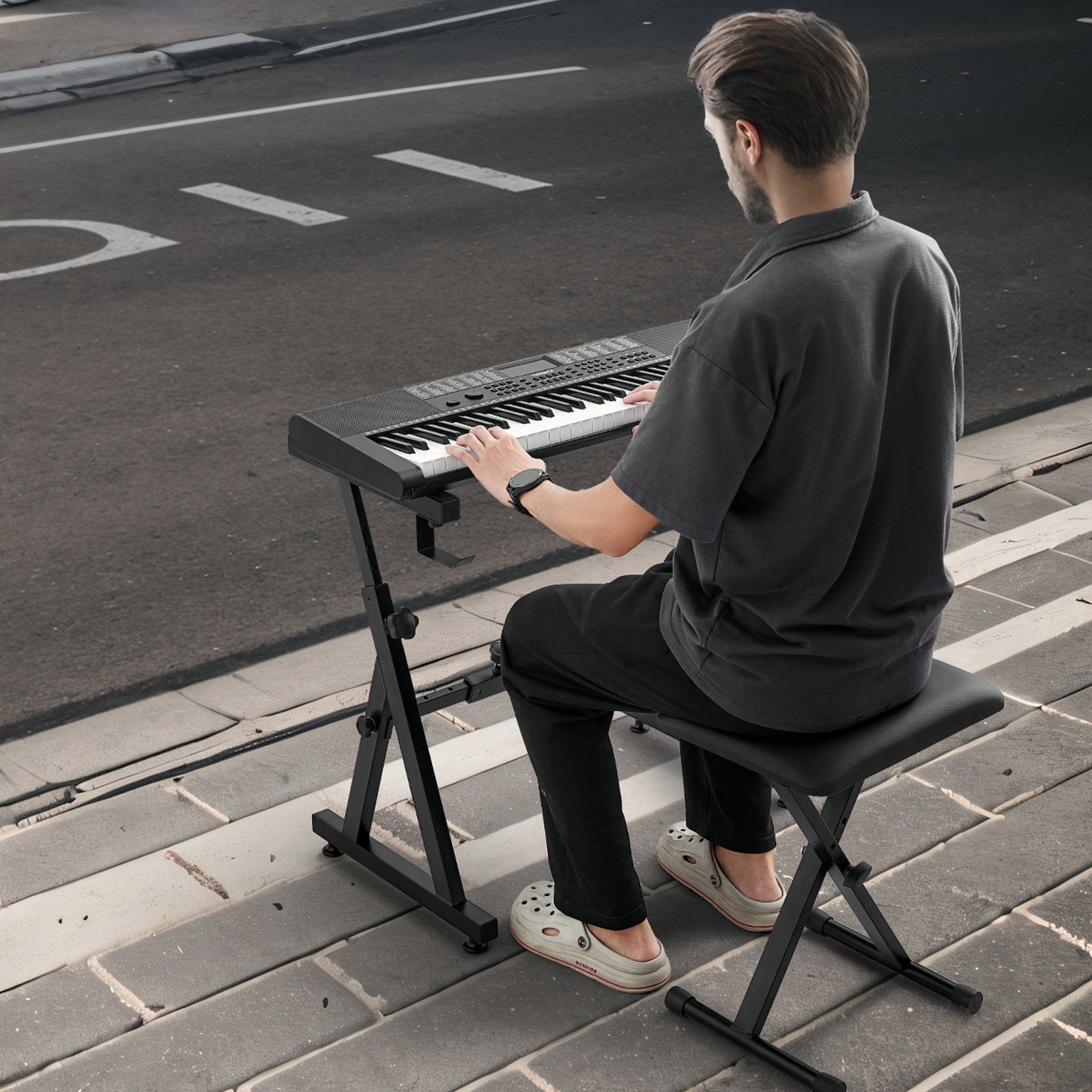 Hombre tocando el teclado en el soporte del teclado de piano VEVOR en la acera de la calle.
