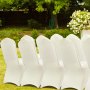 Fundas de silla blancas VEVOR ordenadas al aire libre con un jardín verde de fondo.