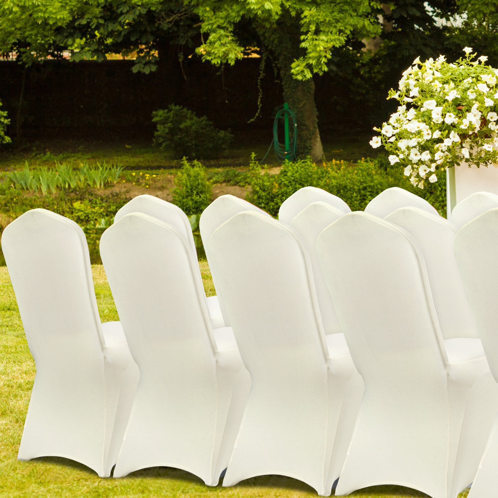 Fundas de silla blancas VEVOR ordenadas al aire libre con un jardín verde de fondo.