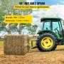 tractor using VEVOR hay bale spear to lift a hay bale in a field.