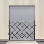 black VEVOR folding security gate against a closed grey warehouse door.