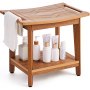 wooden VEVOR shower bench with towel rack, storage shelf, and assorted bath products on white background.