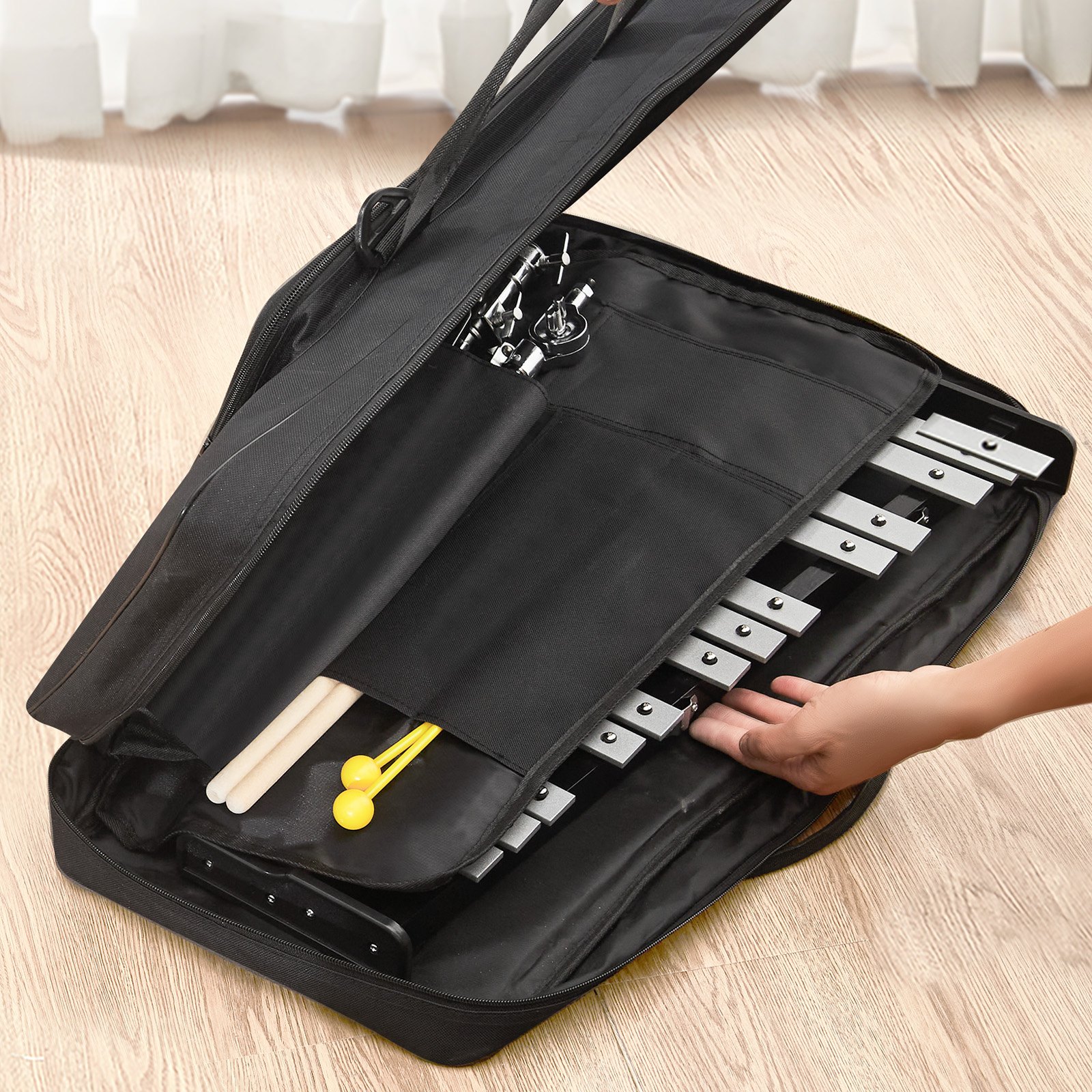 VEVOR glockenspiel kit in black carrying bag with mallets on light wood floor.