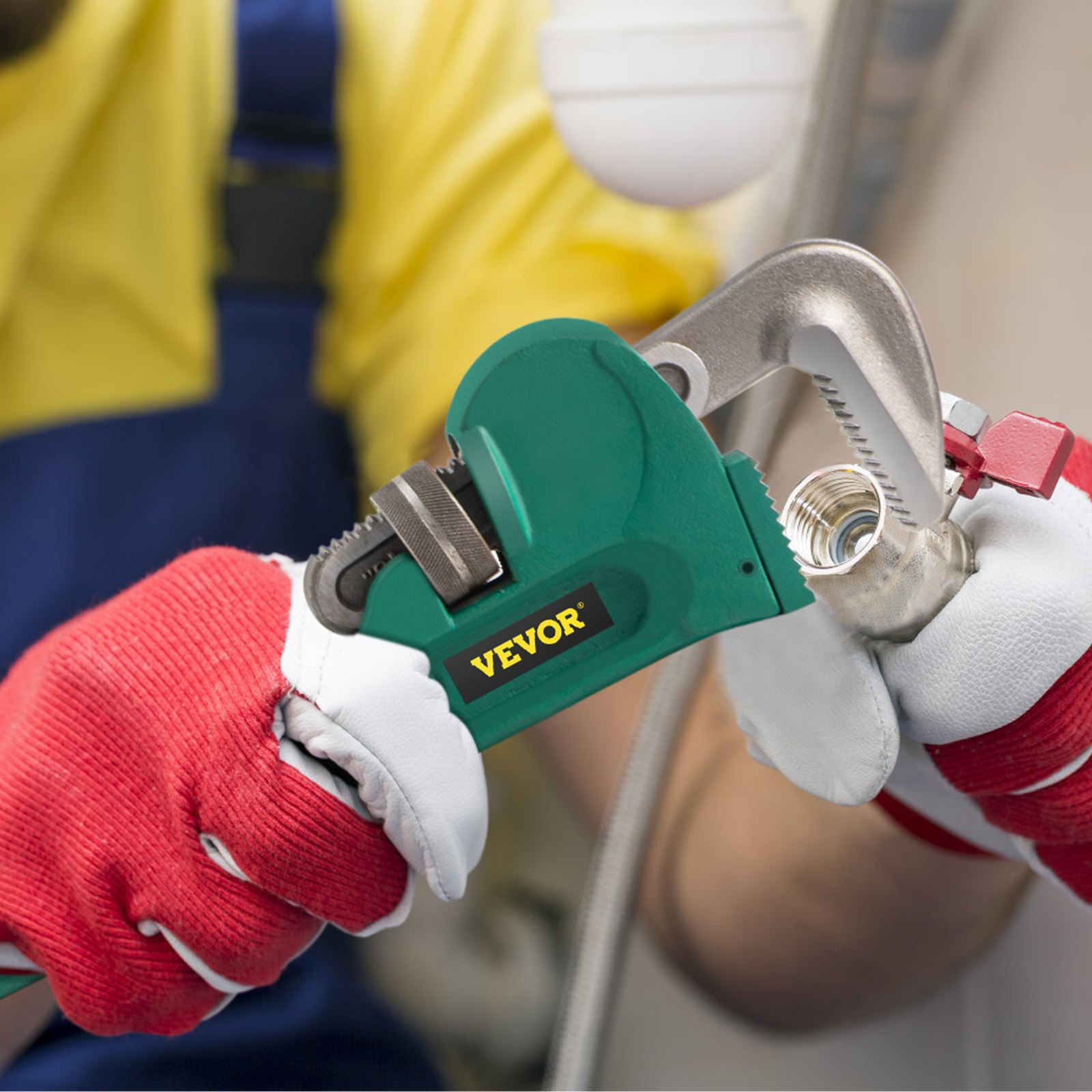worker using a VEVOR pipe wrench to tighten a metal pipe, wearing red gloves.