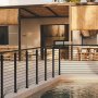 modern poolside patio with VEVOR cable railing post, bamboo roof, and wicker furniture in a cozy setting.